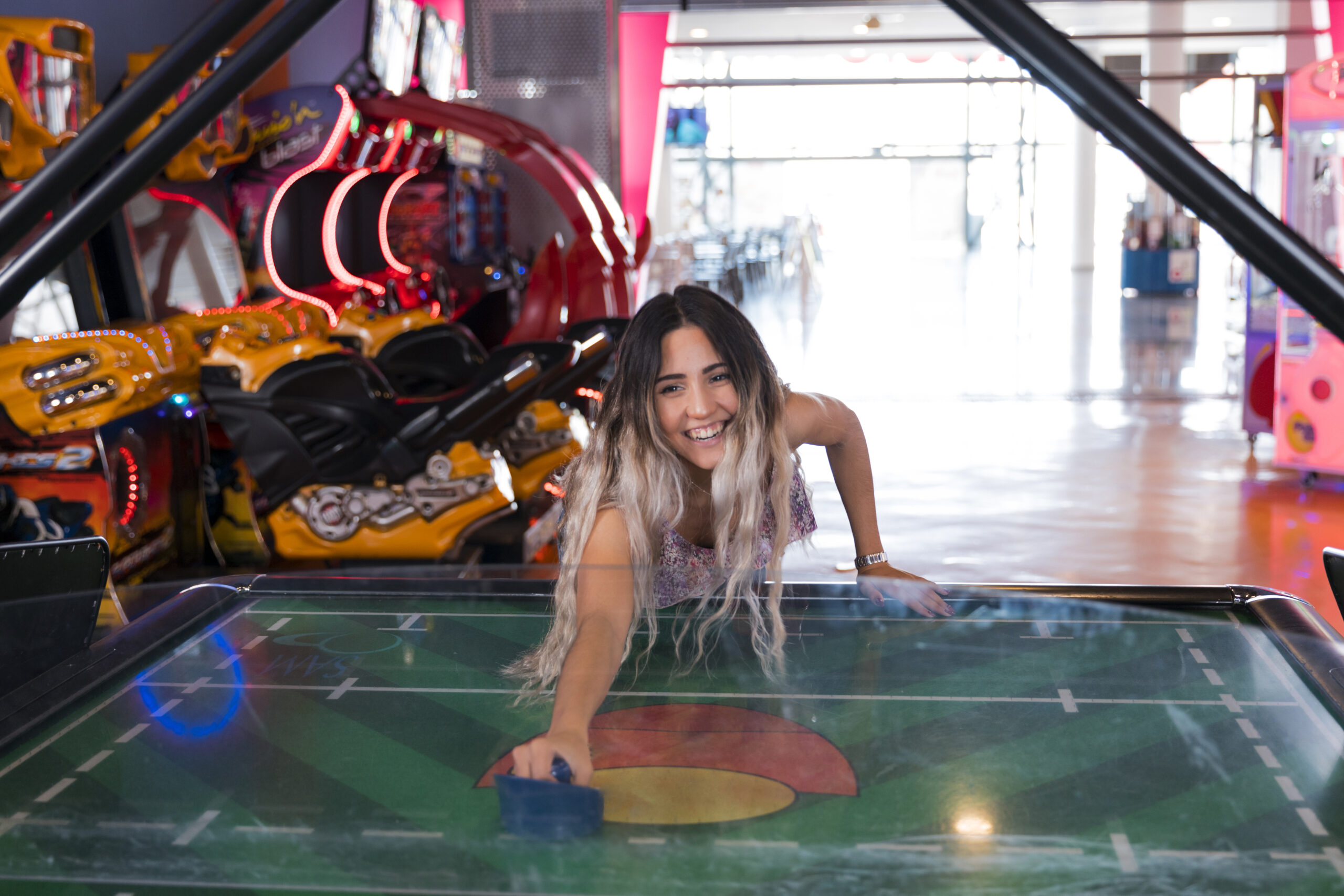 front view smilling woman playing air hockey
